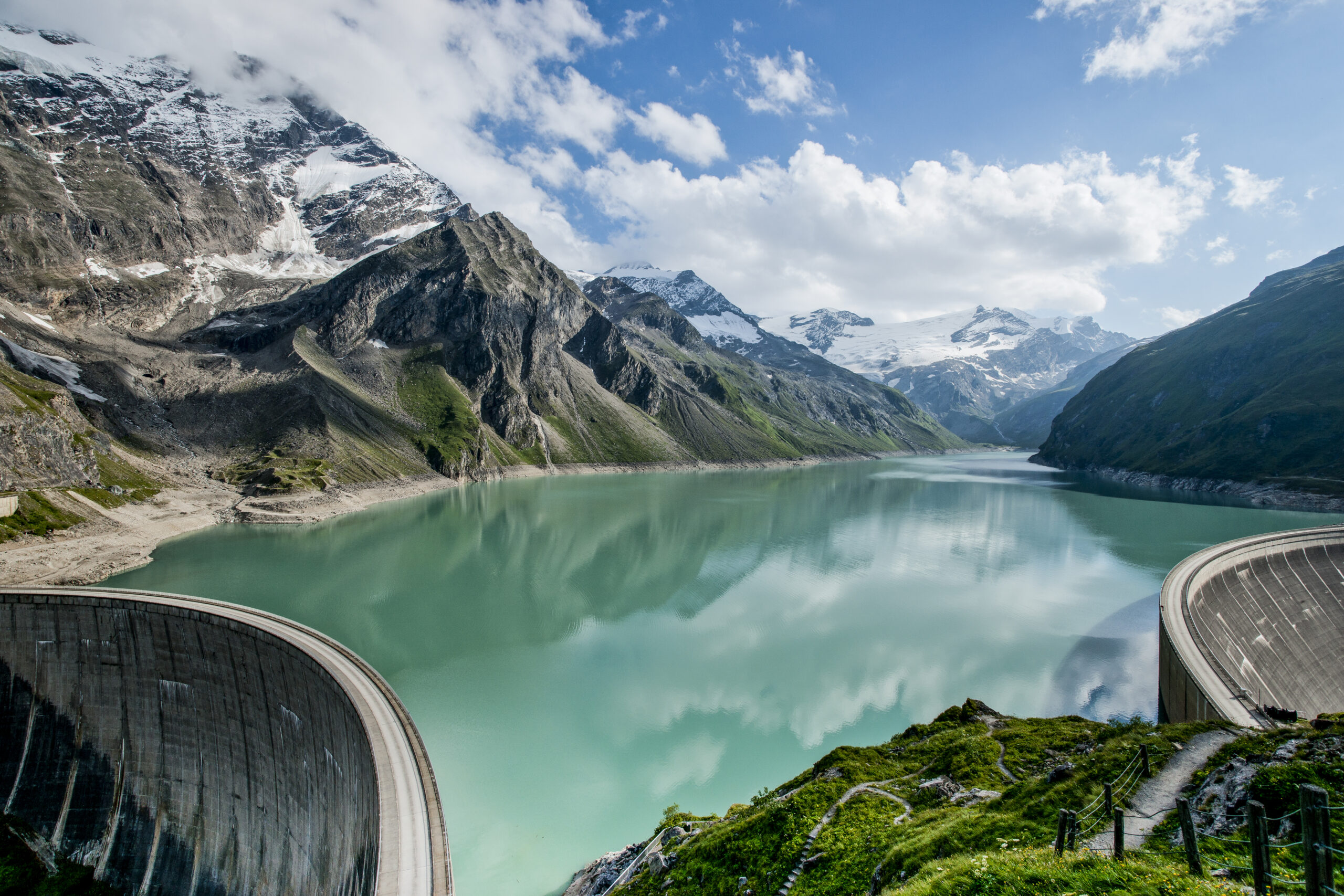 Kaprun Hochgebirgsstauseen: Blick vom Aussichtspunkt Höhenburg auf den Stausee Mooserboden. Links die 112 Meter hohe Drossensperre, rechts die 107 Meter hohe Moosersperre, dahinter das Gebirge der Hohen Tauern © Verbund Tourismus Maxum