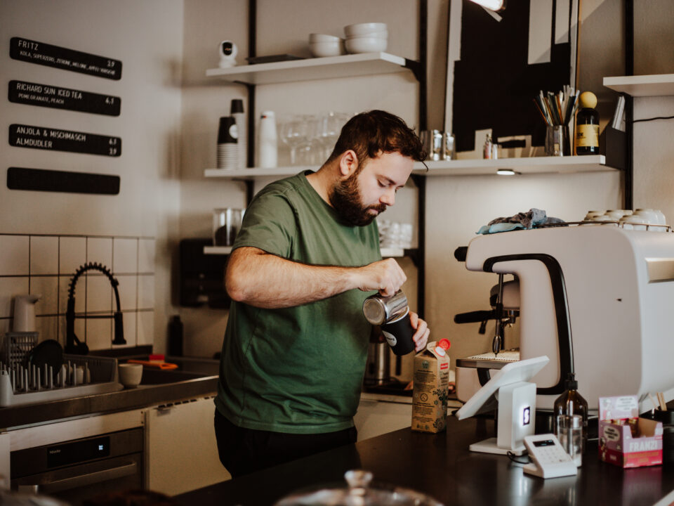 Inhaber Inhaber Robin Limpek bereitet uns einen Kaffee zu.